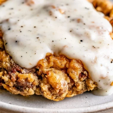 Delicious Chicken Fried Steak served with creamy gravy and sides on a plate.