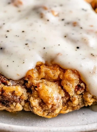 Delicious Chicken Fried Steak served with creamy gravy and sides on a plate.