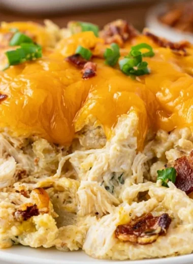 Cozy Crack Chicken Casserole topped with cheese and herbs in a baking dish
