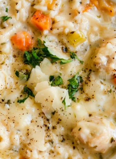 Bowl of creamy chicken rice soup with herbs and vegetables