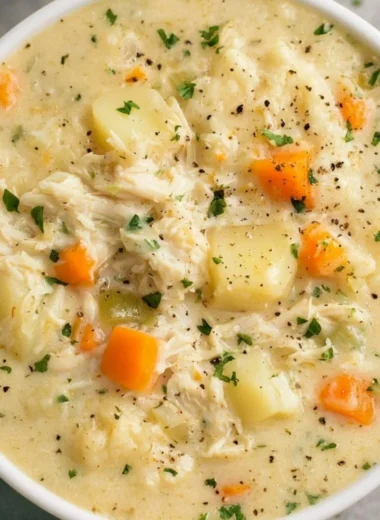 Delicious high protein chicken pot pie soup served in a bowl with vegetables.