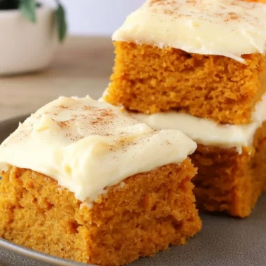 Delicious Paula Deen pumpkin bars topped with cream cheese frosting and spices.