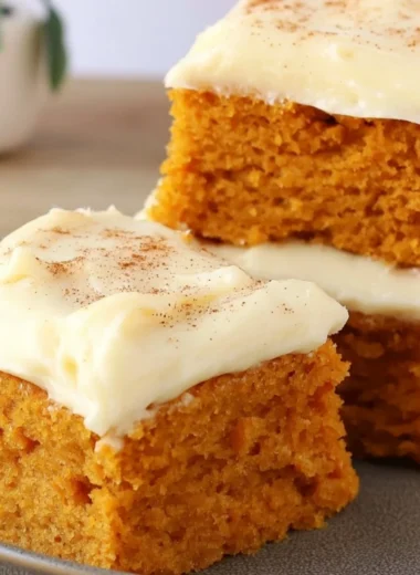 Delicious Paula Deen pumpkin bars topped with cream cheese frosting and spices.
