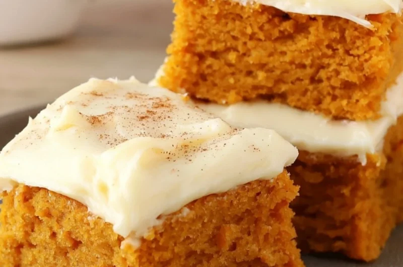 Delicious Paula Deen pumpkin bars topped with cream cheese frosting and spices.