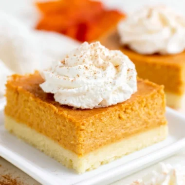 Delicious pumpkin pie bars with a buttery shortbread crust on a plate