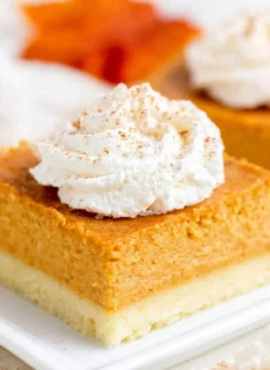 Delicious pumpkin pie bars with a buttery shortbread crust on a plate