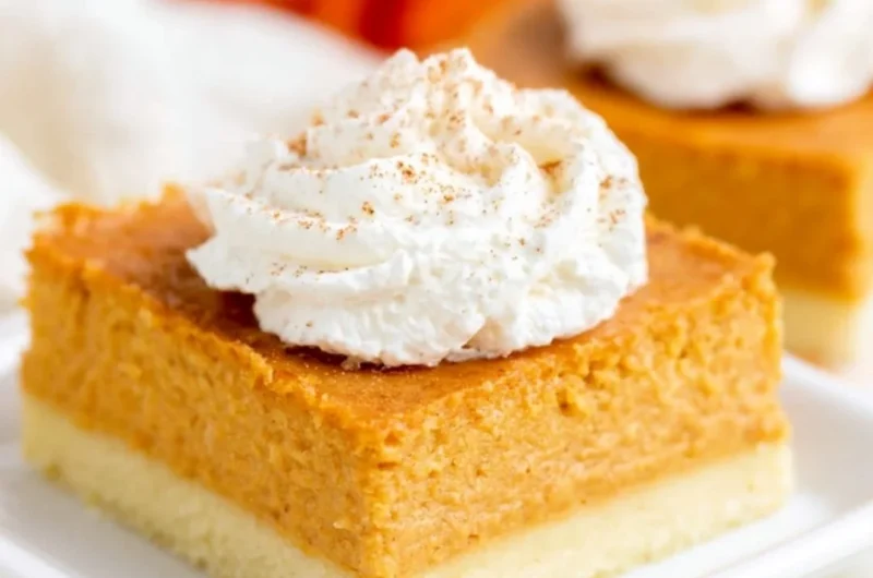 Delicious pumpkin pie bars with a buttery shortbread crust on a plate