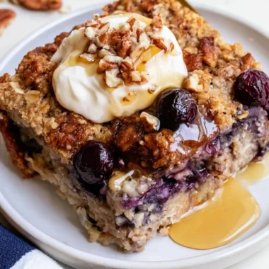 Bowl of blueberry baked oatmeal topped with fresh blueberries and almonds