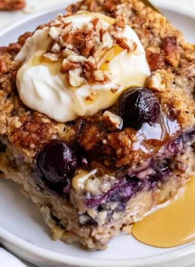 Bowl of blueberry baked oatmeal topped with fresh blueberries and almonds