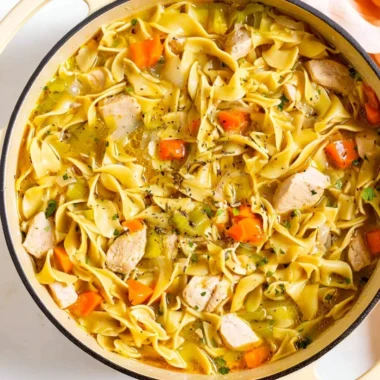 Bowl of homemade Dutch Oven Chicken Noodle Soup with fresh ingredients.