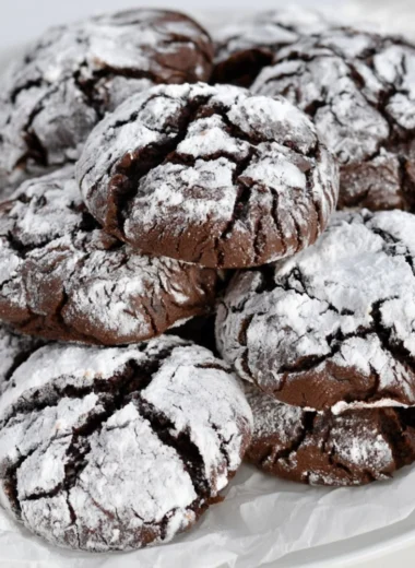 Easy chocolate crinkle cookies dusted with powdered sugar on a baking tray.