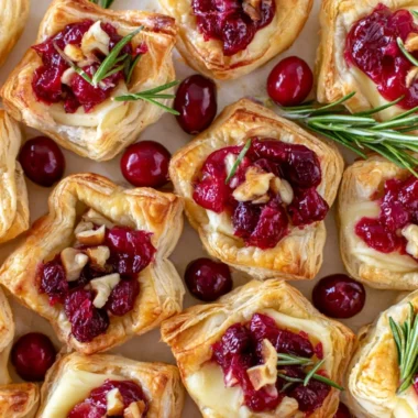 Easy cranberry brie bites with puff pastry on a baking sheet.