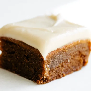 Gingerbread cookie bars with cream cheese frosting on a festive plate
