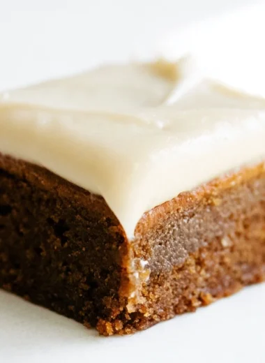 Gingerbread cookie bars with cream cheese frosting on a festive plate