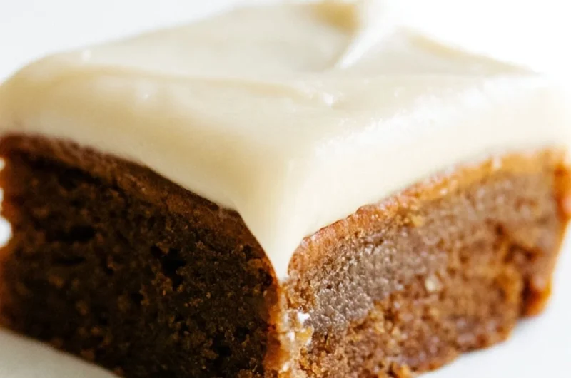 Gingerbread cookie bars with cream cheese frosting on a festive plate