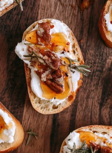 Whipped feta crostini topped with hot honey on a wooden platter